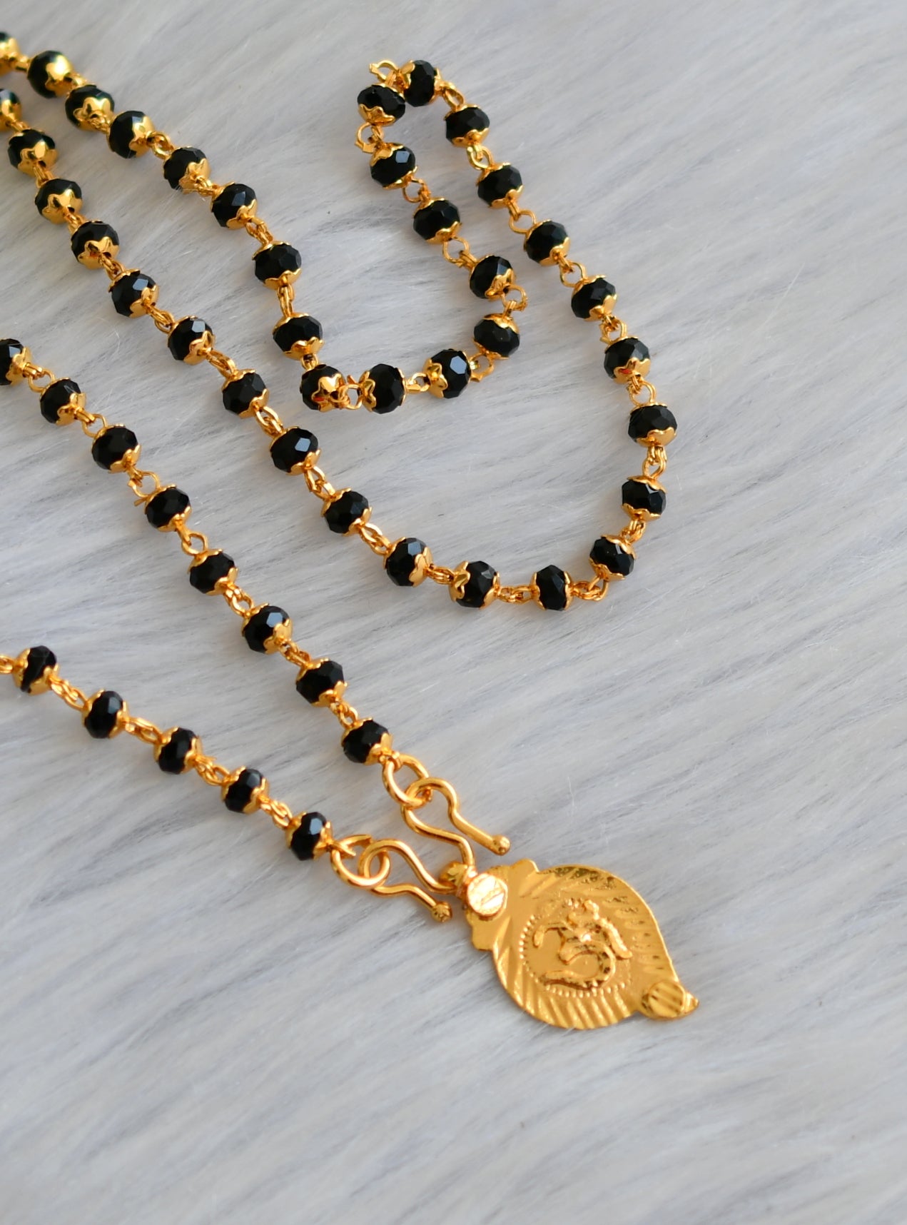 Gold tone 'om' pendant with karimani chain dj-41087